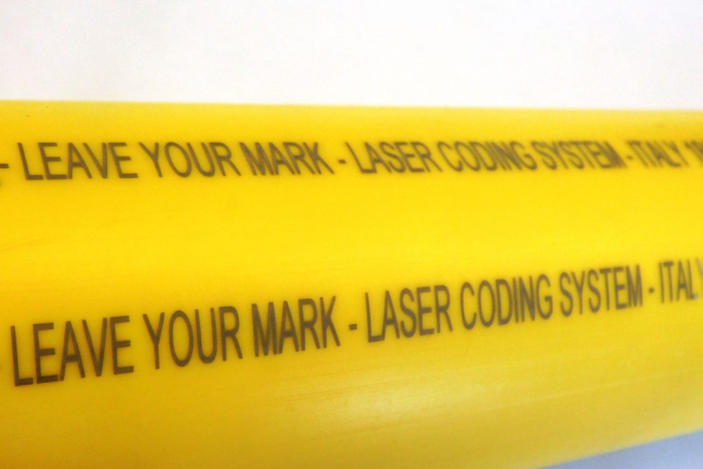 Farbige Markierung mit UV-Laser auf einer gelben PEHD-Rohrleitung für Gas.